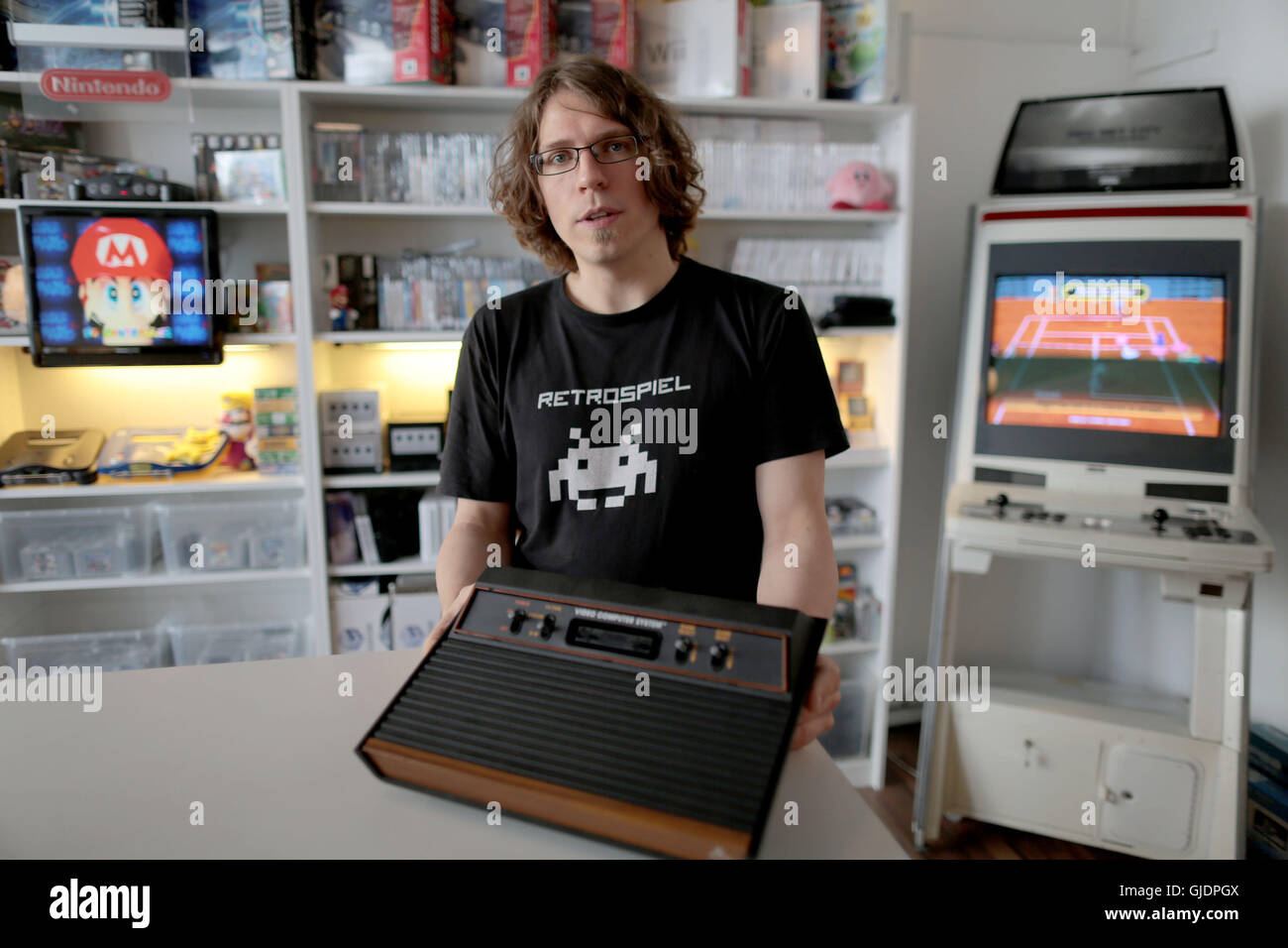 Cologne, Germany. 5th Aug, 2016. Christoph Noll, owner of a store for retro games, presenting an Atari 2600 console in Cologne, Germany, 5 August 2016. May games of this year's Gamescom present present opulant grahpics. But the trend for pixel looks and old consoles is still popular. PHOTO: OLIVER BERG/dpa/Alamy Live News Stock Photo