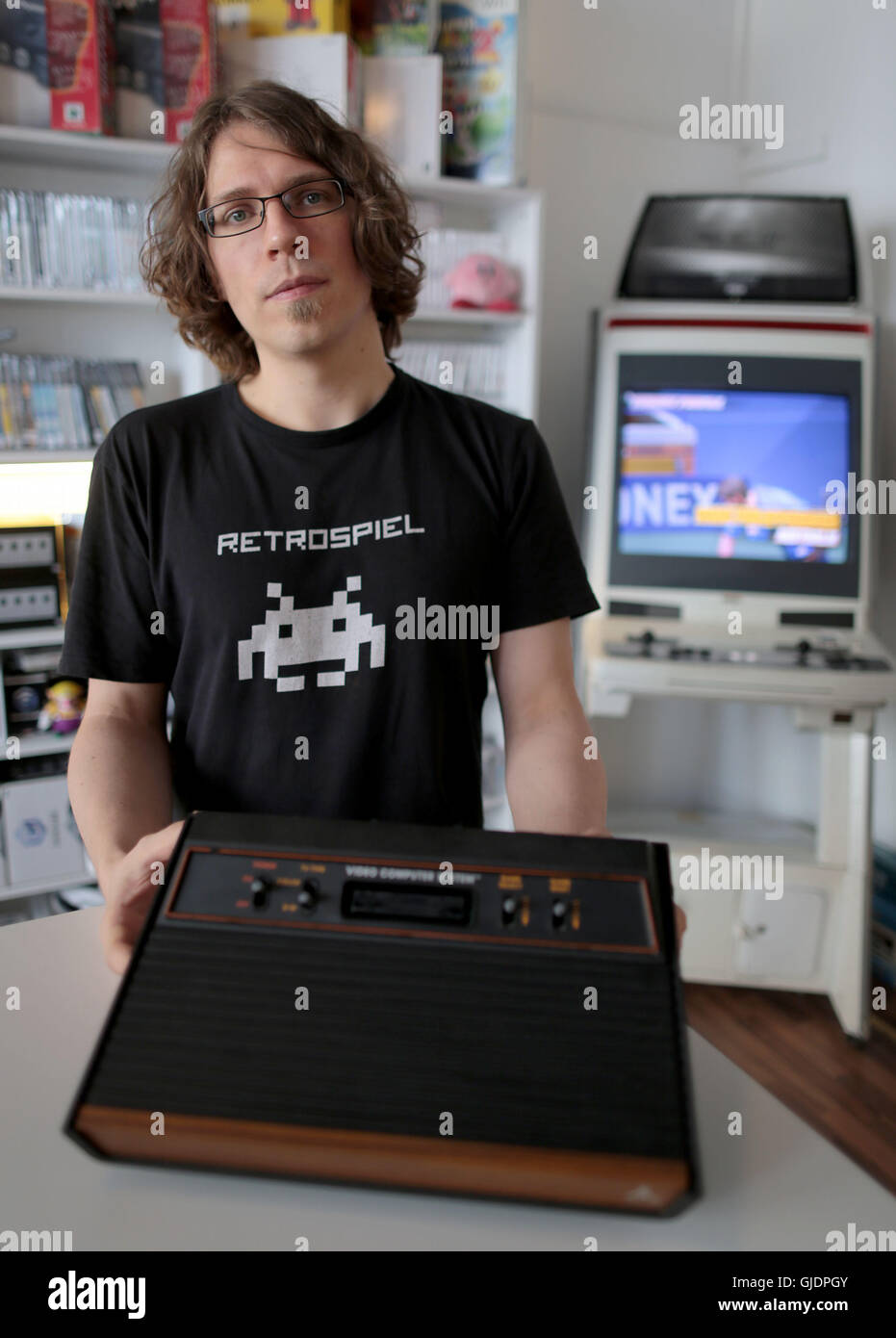 Cologne, Germany. 5th Aug, 2016. Christoph Noll, owner of a store for retro games, presenting an Atari 2600 console in Cologne, Germany, 5 August 2016. May games of this year's Gamescom present present opulant grahpics. But the trend for pixel looks and old consoles is still popular. PHOTO: OLIVER BERG/dpa/Alamy Live News Stock Photo