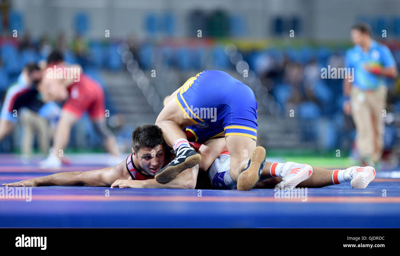 Rio de Janeiro, Brazil. 15th Aug, 2016. Denis Maksymilian Kudla (red) of  Germany and Zhanarbek Kenzheev of Kyrgyzstan in action during the Men's  Greco-Roman 85 kg Qualification of the Wrestling events during