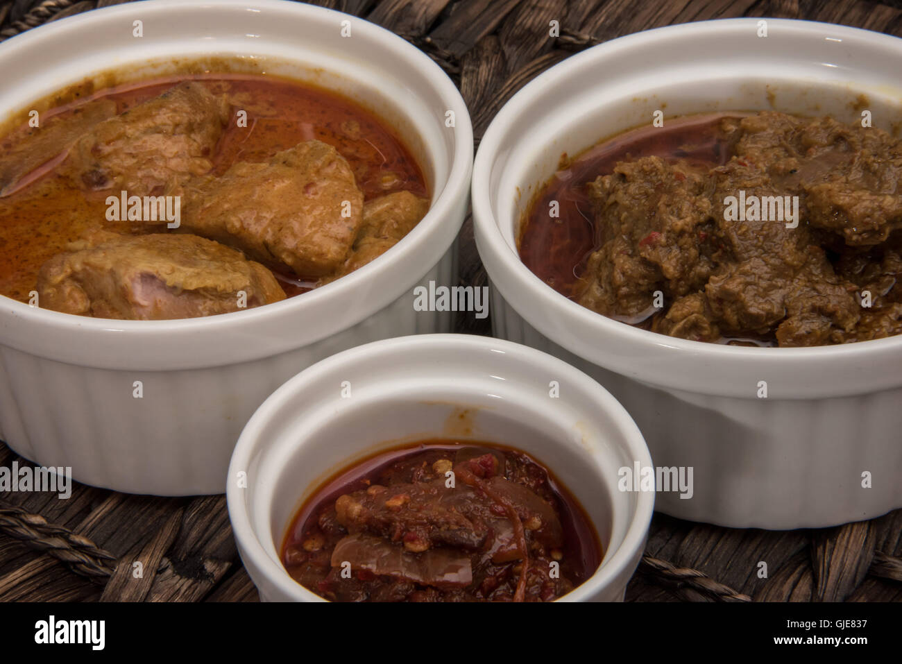 Beef Rendang, chicken curry and sambal in ramekin Stock Photo