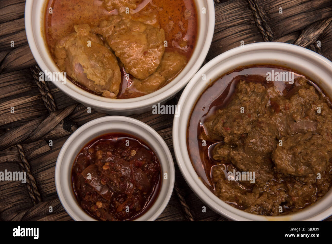 Beef Rendang, chicken curry and sambal in ramekin Stock Photo