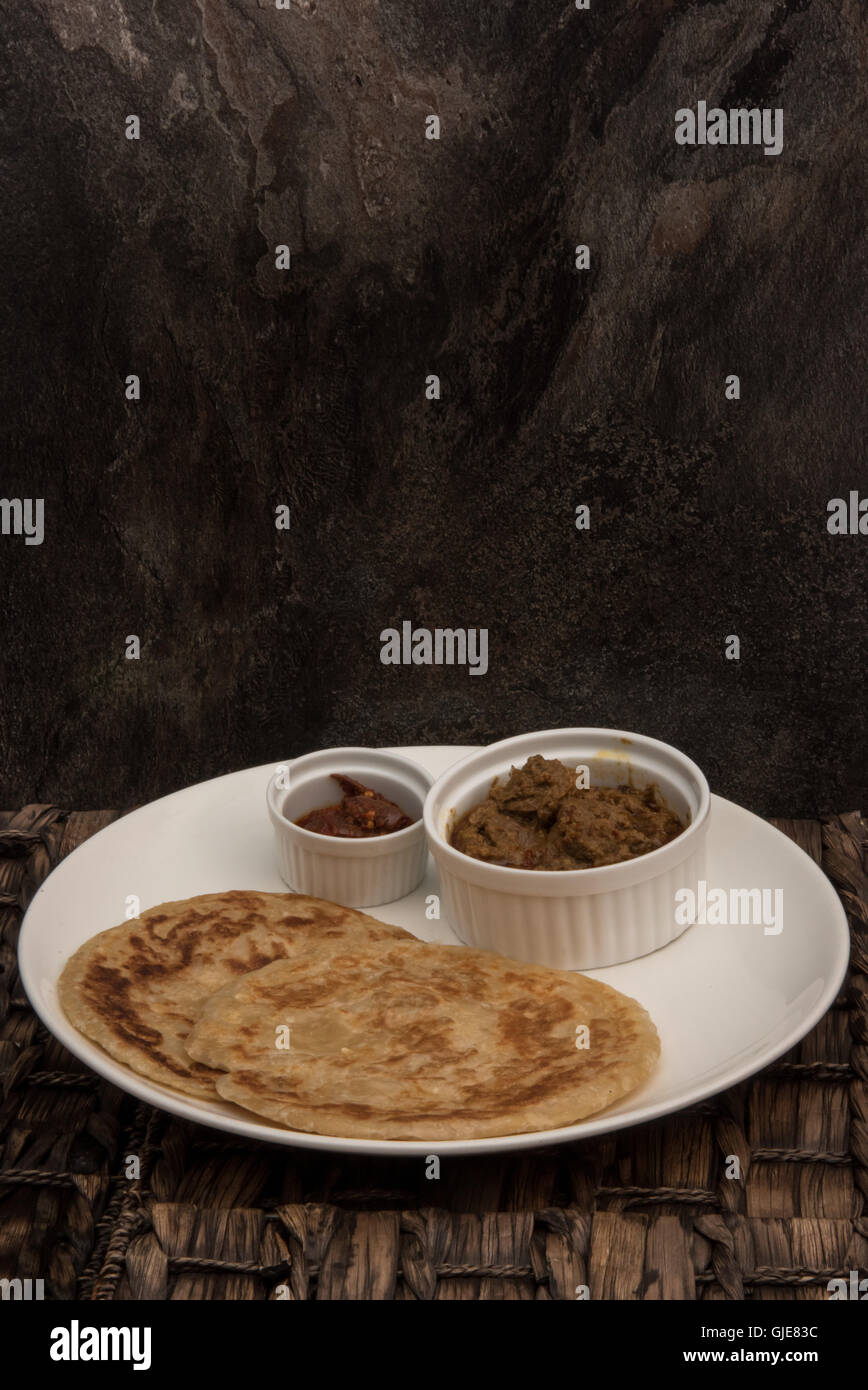 Roti Canai with chicken curry, sambal paste and 2 pieces of roti Stock Photo