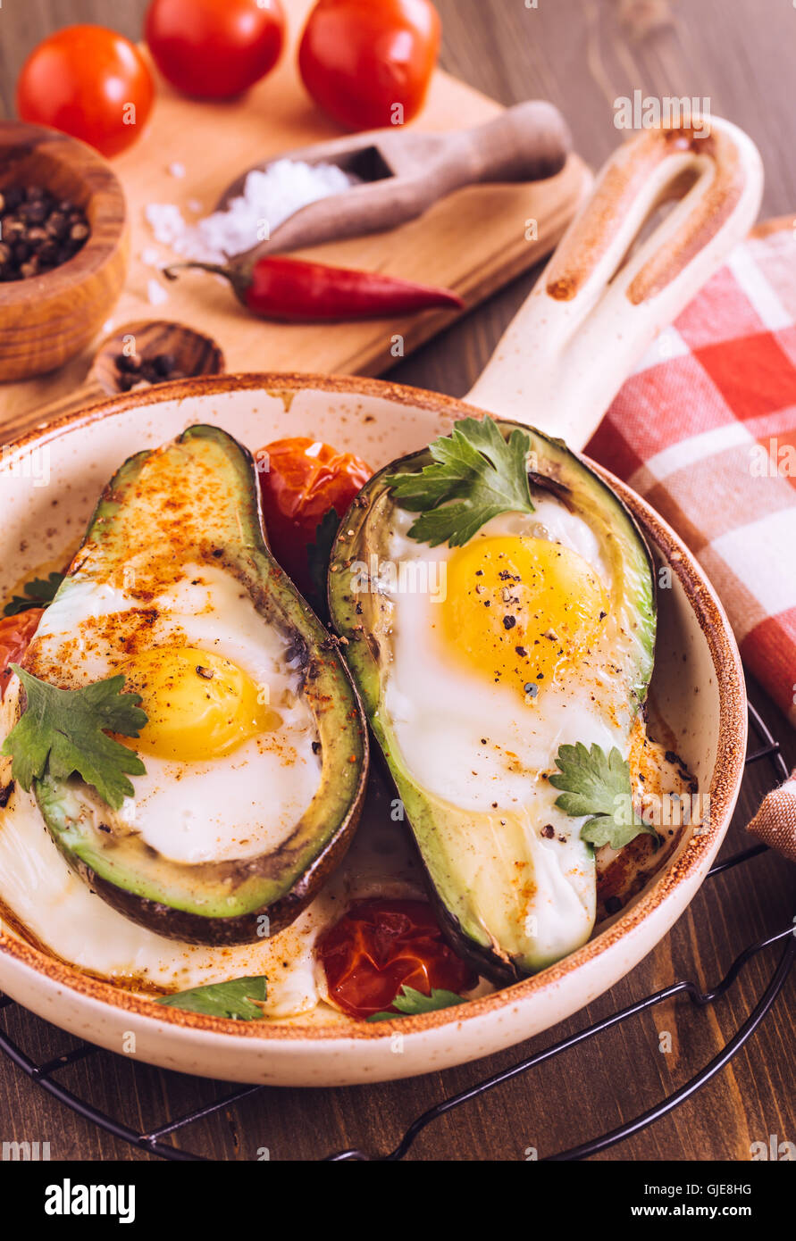 Avocado baked with egg on serving pan Stock Photo Alamy