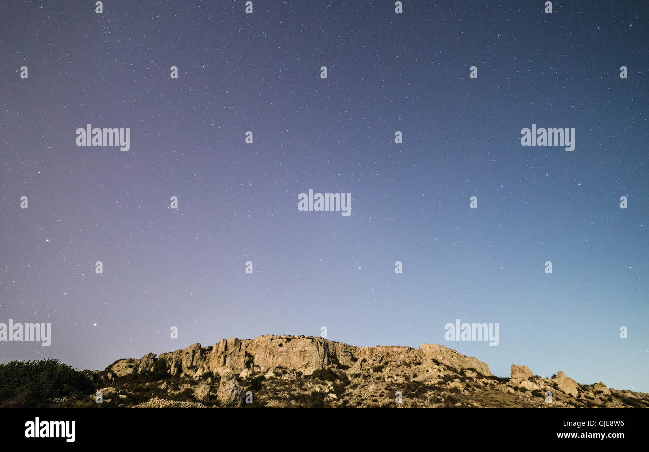 The cliff face at Mgiebah Bay in Malta, under a starry sky. Stock Photo