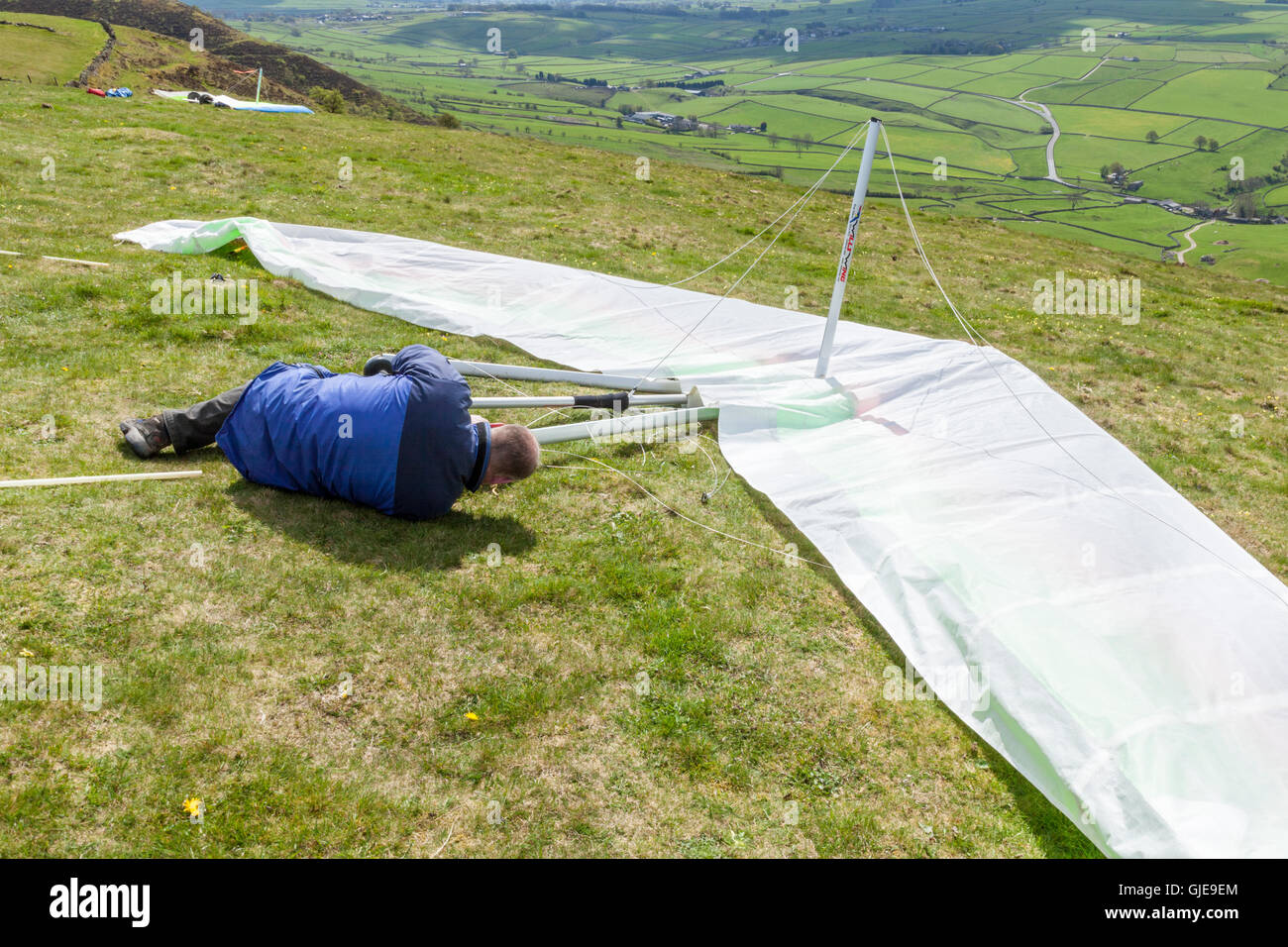 Person assembling or rigging a hang glider at Bradwell Edge, Derbyshire, Peak District, England, UK Stock Photo