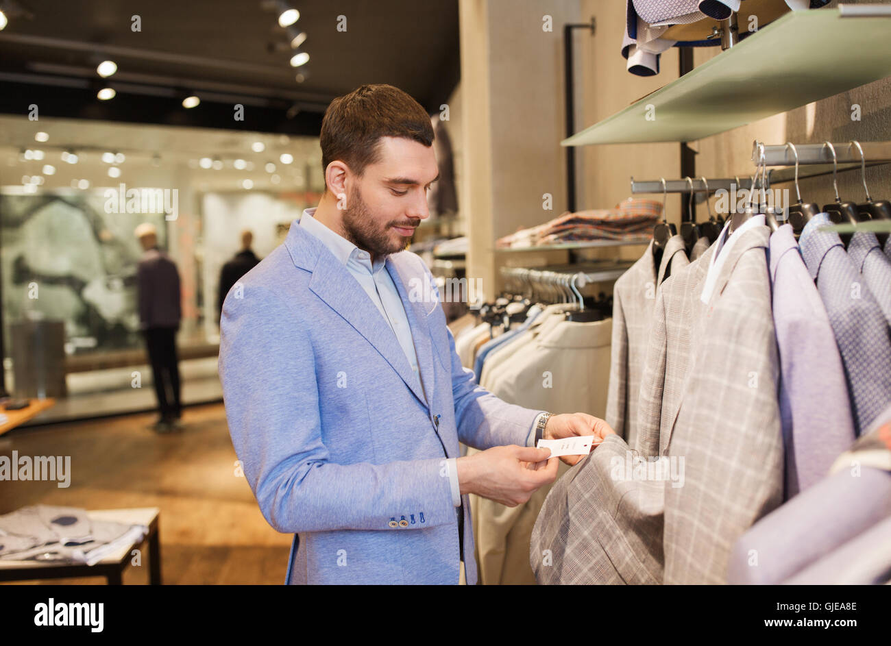happy young man choosing clothes in clothing store Stock Photo - Alamy