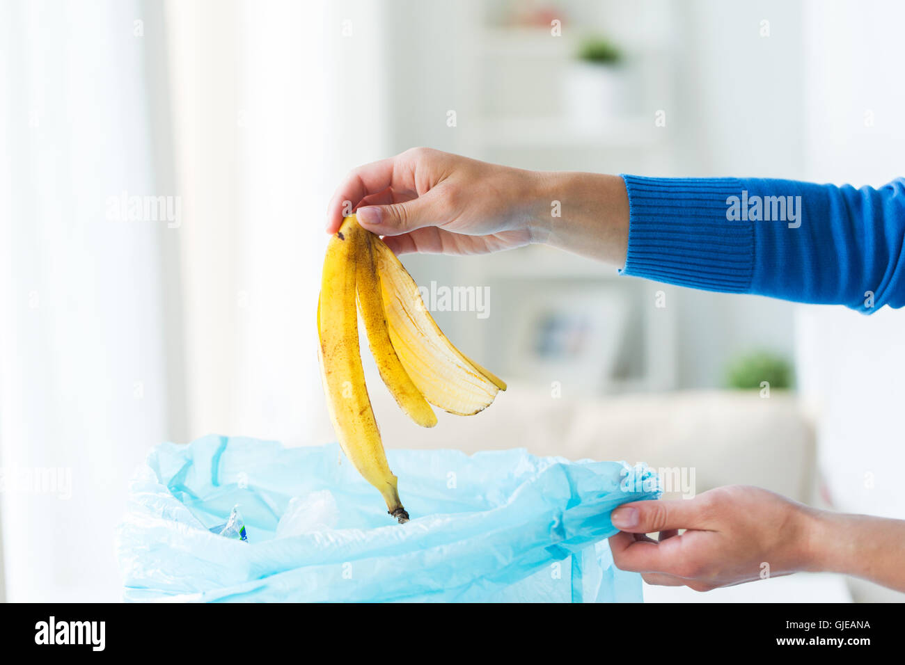 close up of hand putting food waste to rubbish bag Stock Photo