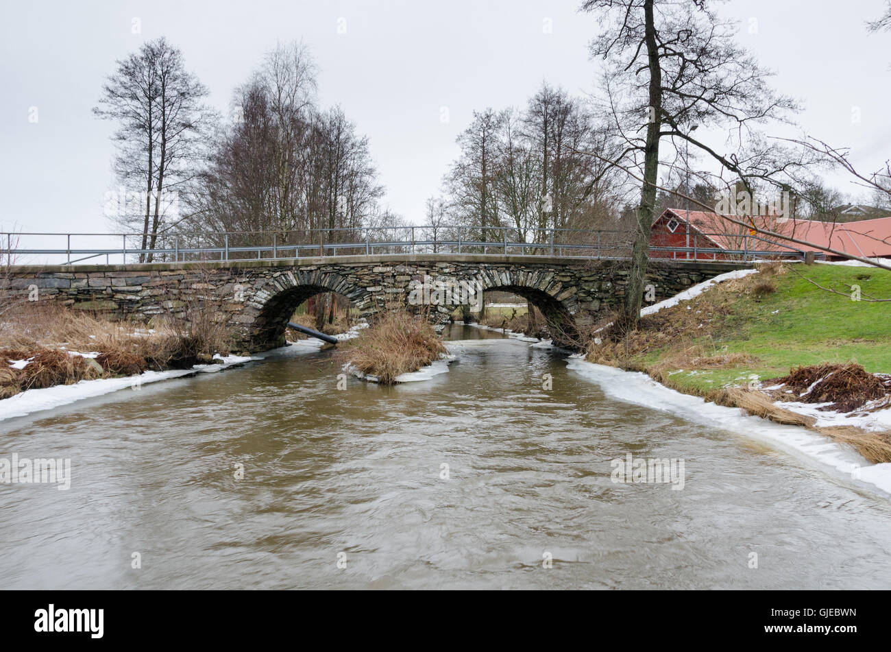 old stonebridge over the cold water one grey day in early spring Stock Photo