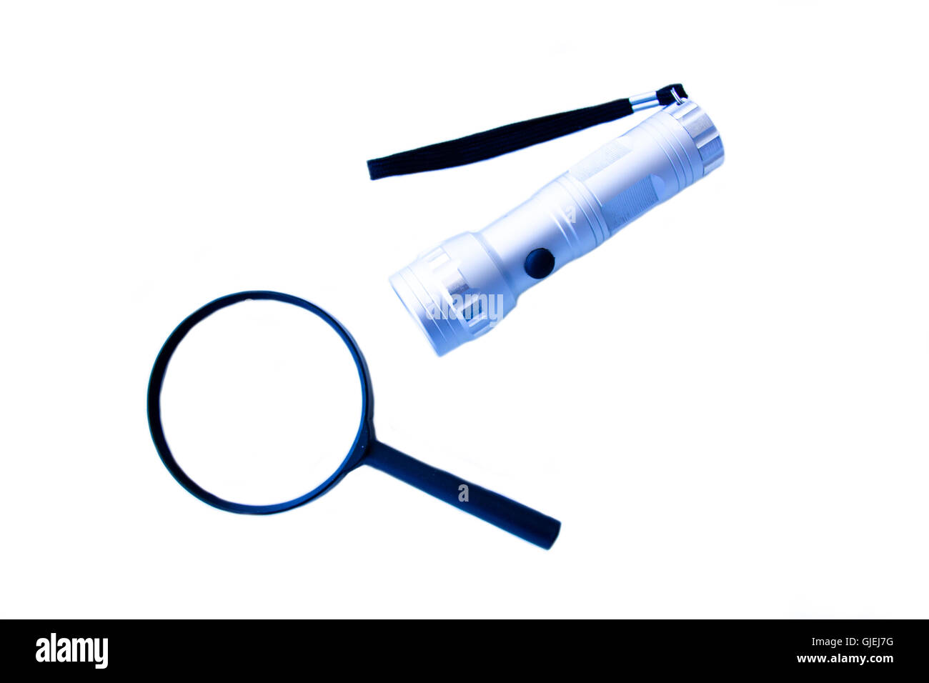 Magnifying glass and flashlight on a white background seen from above Stock Photo