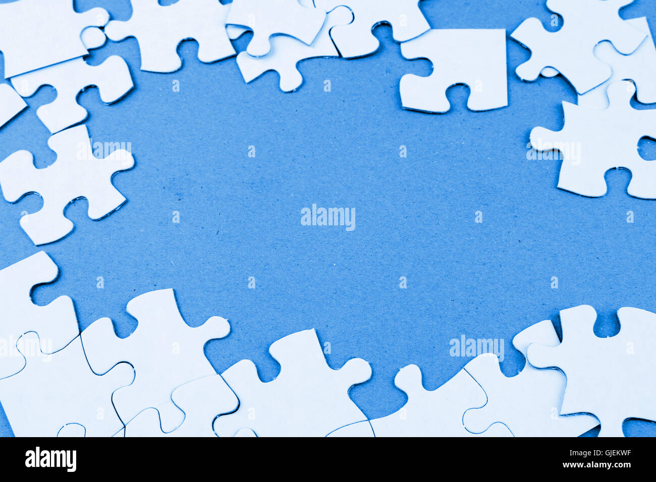 Loose jigsaw puzzle pieces on blue background Stock Photo