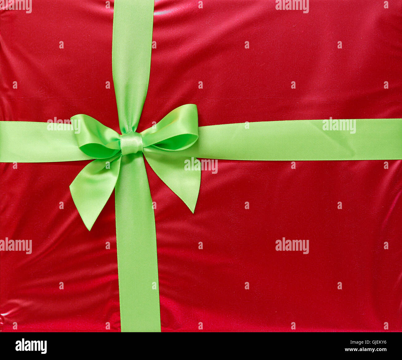Green ribbon and bow on red gift paper Stock Photo