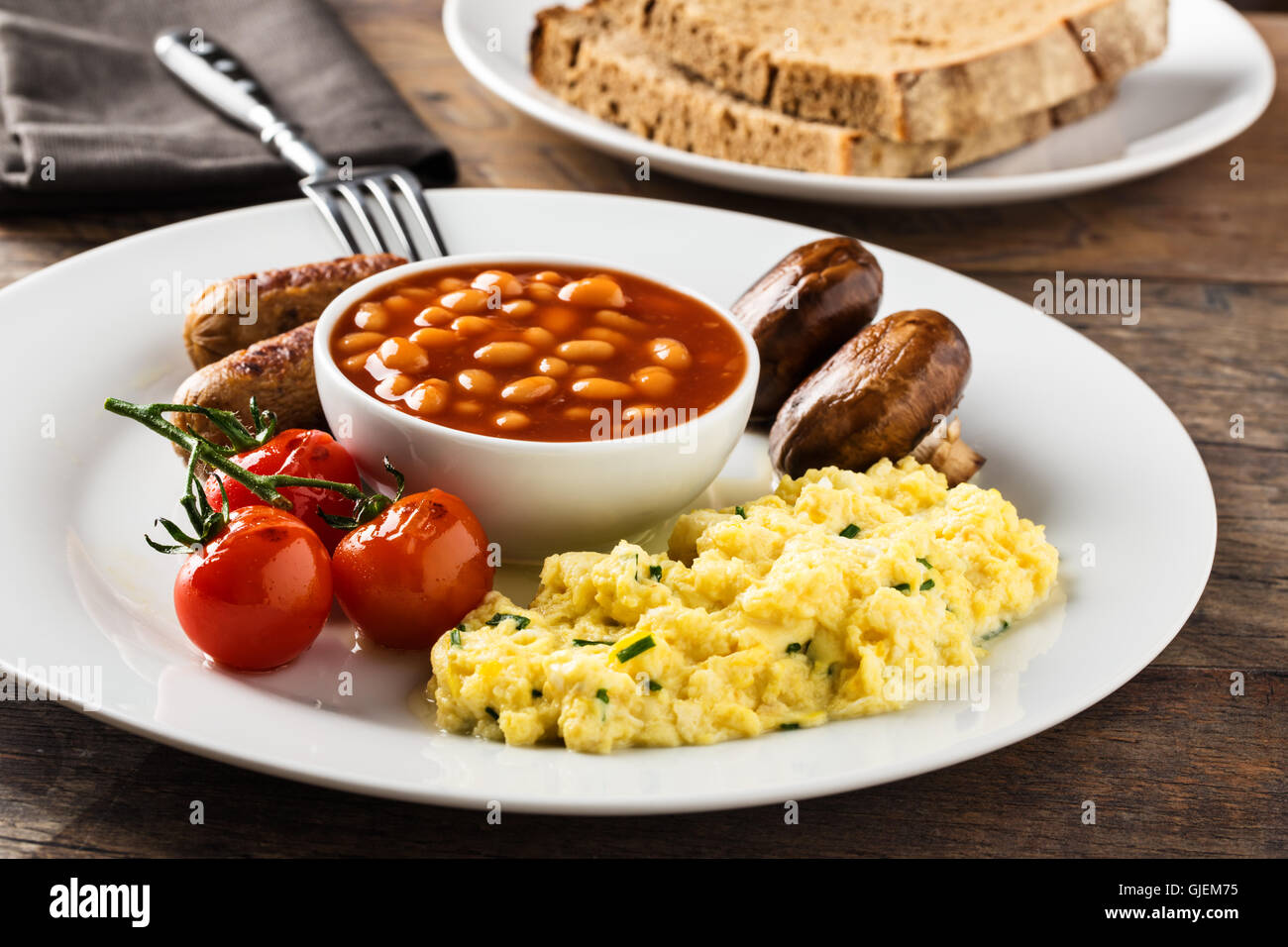 Breakfast with sausages, scrambled eggs, baked beans, mushrooms and