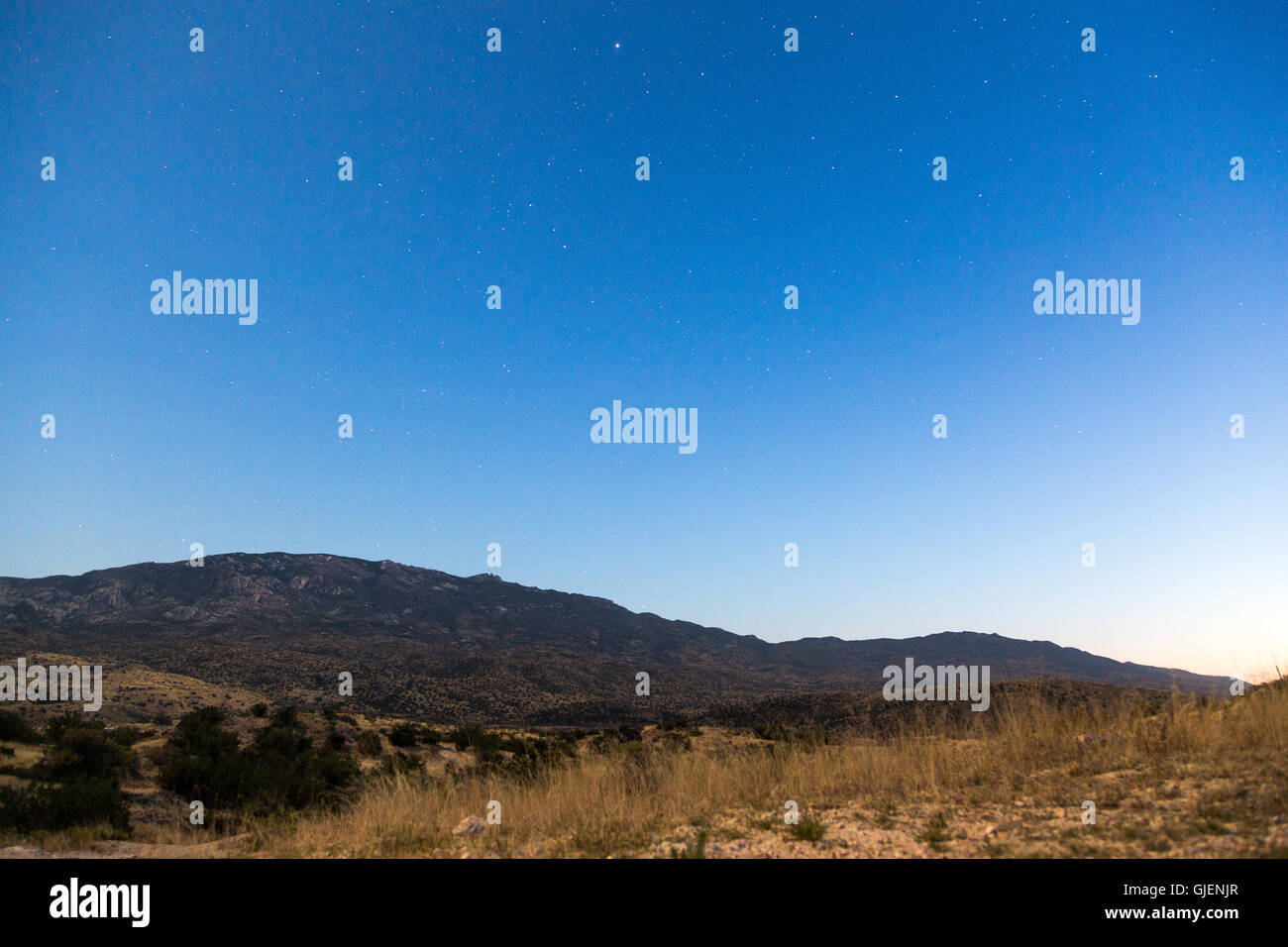 A starry night sky beginning to emerge over Mica Mountain and Sonoran Desert grasslands. Coronado National Forest, Arizona Stock Photo