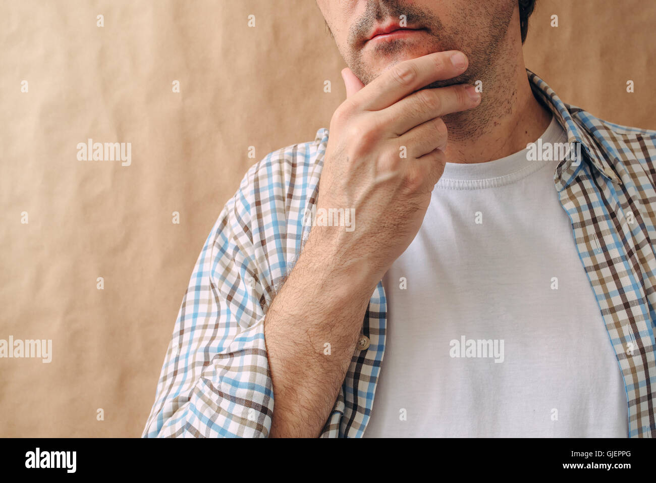Man stroking chin and thinking deep thoughts, making tough decisions Stock Photo