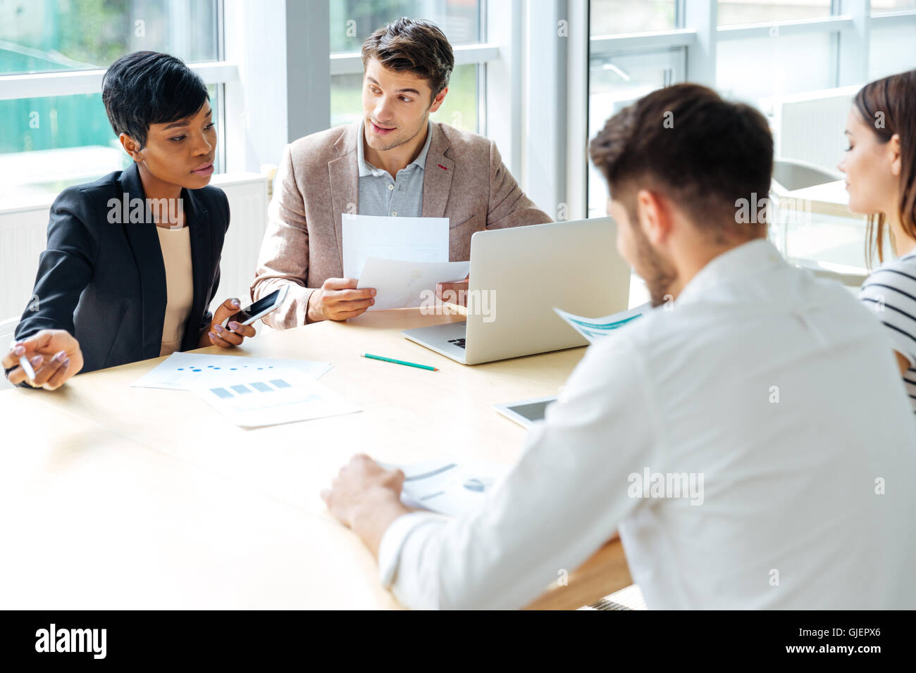 Multiethnic group of young businesspeople working together on business meeting in conference room Stock Photo