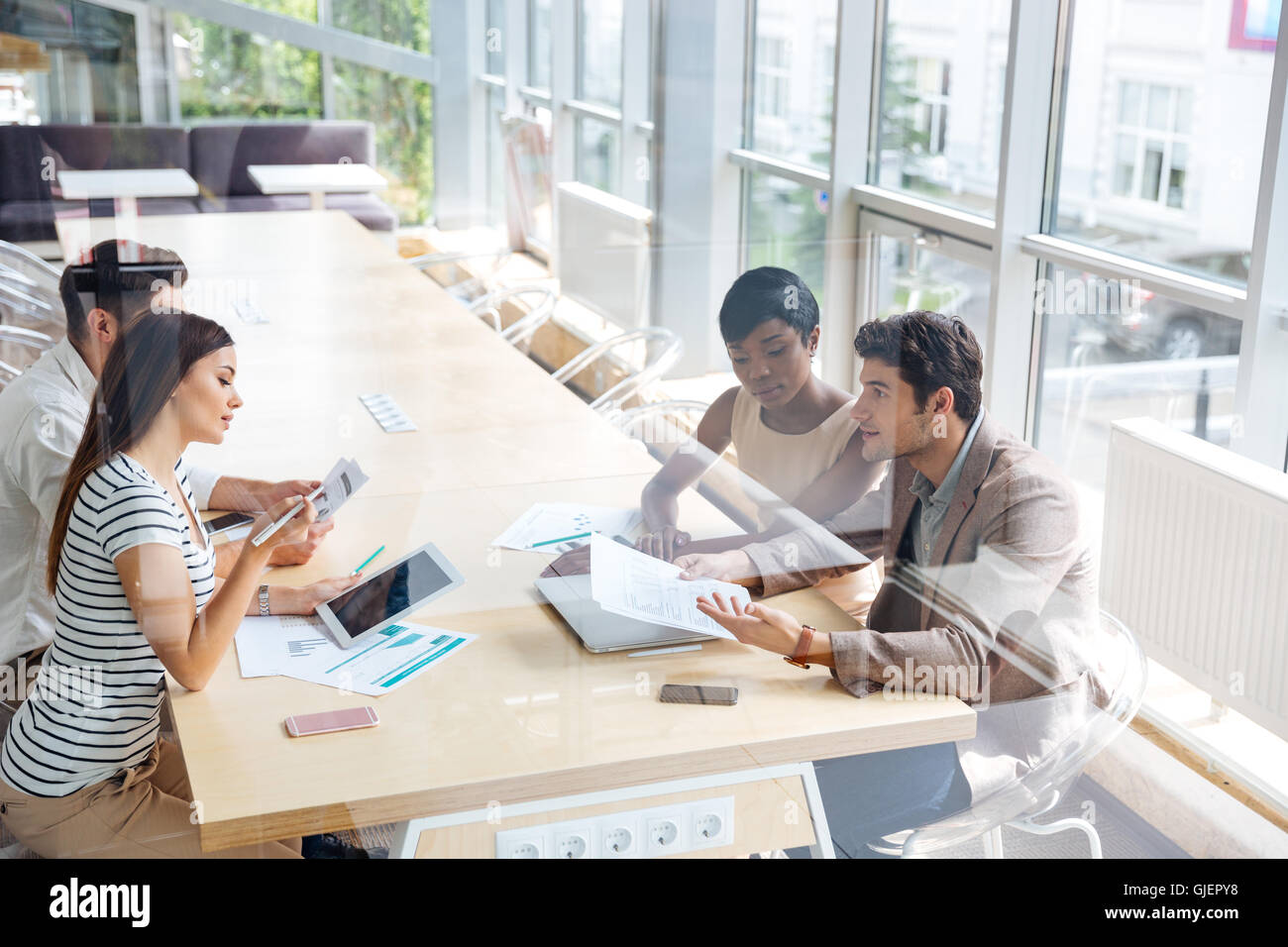 Multiethnic group of young businesspeople working together in conference room Stock Photo