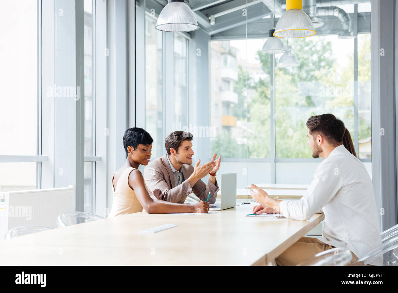 Group of young businesspeople working in office and discussing new ideas Stock Photo