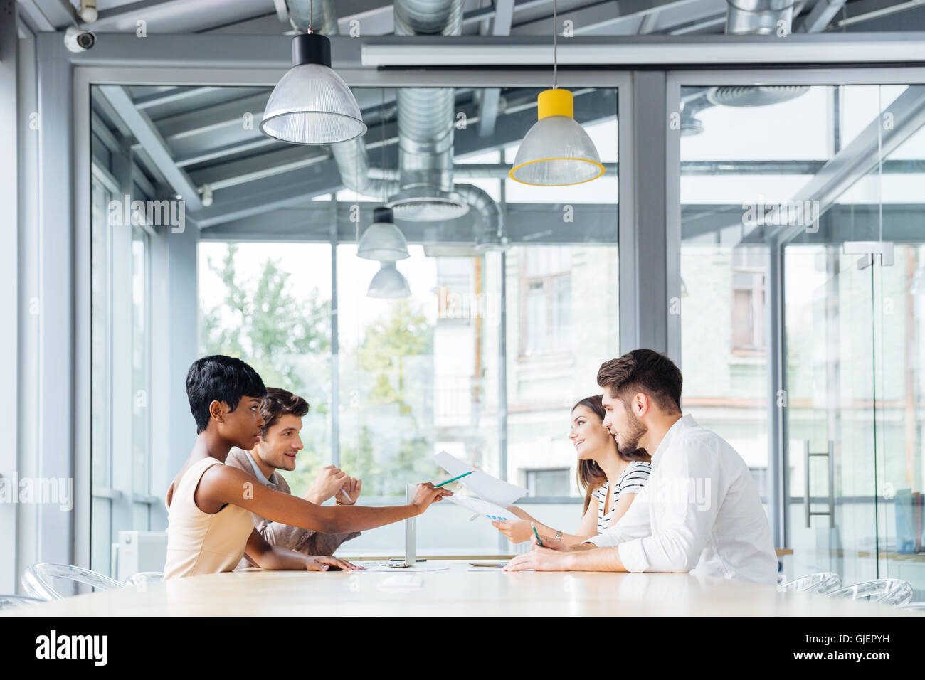 Group of young businesspeople talking and working together in conference room Stock Photo