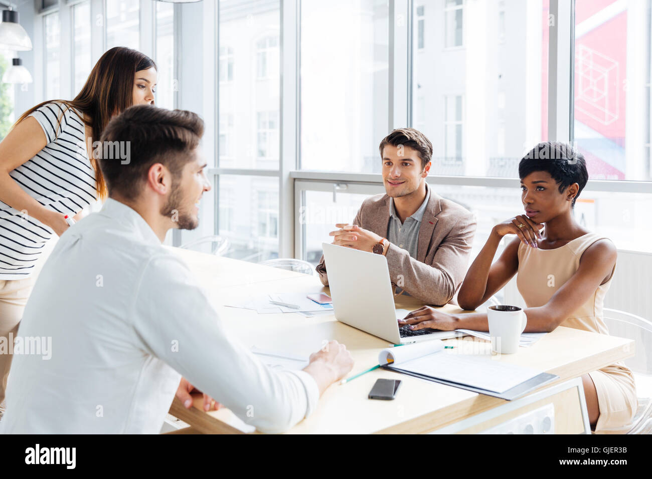Successful young business people talking and working together in office Stock Photo