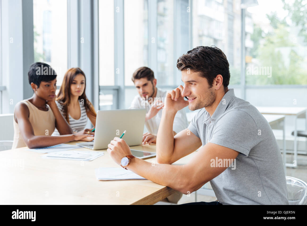 Successful young businessman talking on cell phone on business meeting in conference room Stock Photo