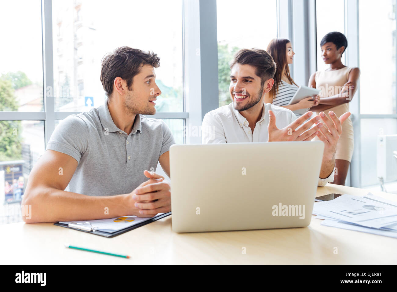Happy young businessmen and businesswomen working in office Stock Photo