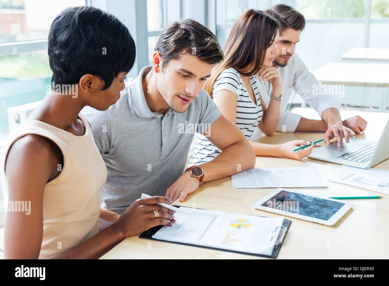 Multiethnic group of young business people creating business plan in office Stock Photo