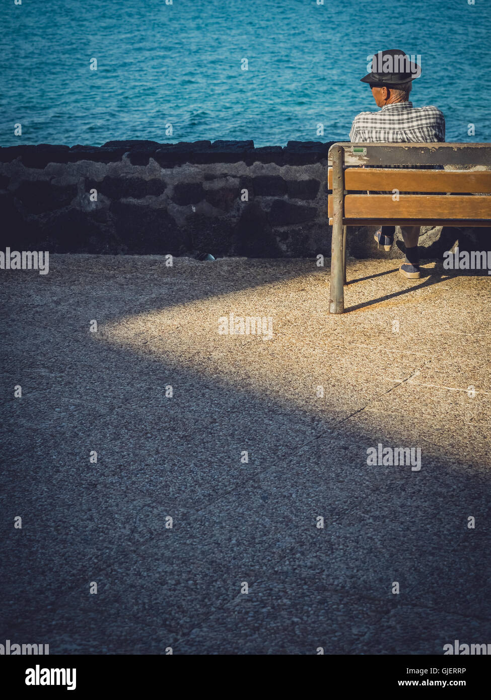 Old Lonely Man Sitting Alone On A Wooden Bench On A Seaside Promenade Stock Photo Alamy