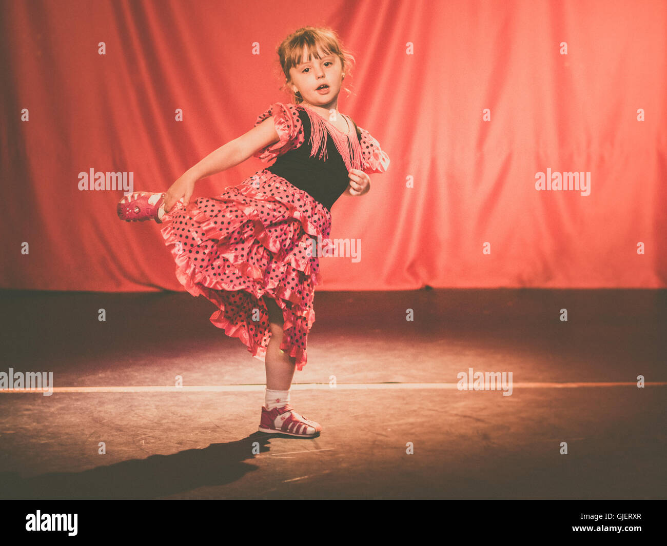 Little four years old girl dancing flamenco on stage in a theater Stock