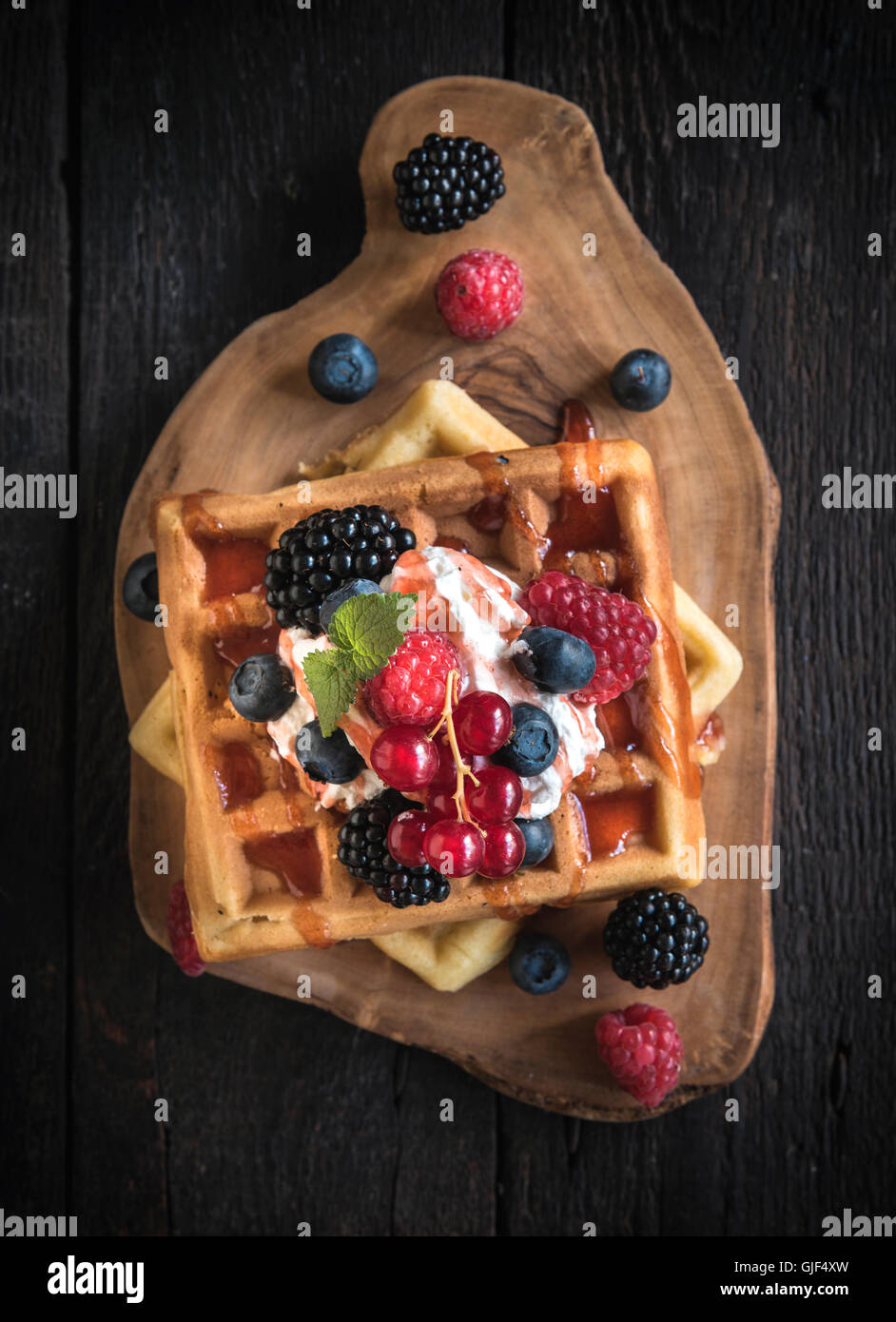 Traditional Belgium waffles with berry fruits and ice cream on wooden ...