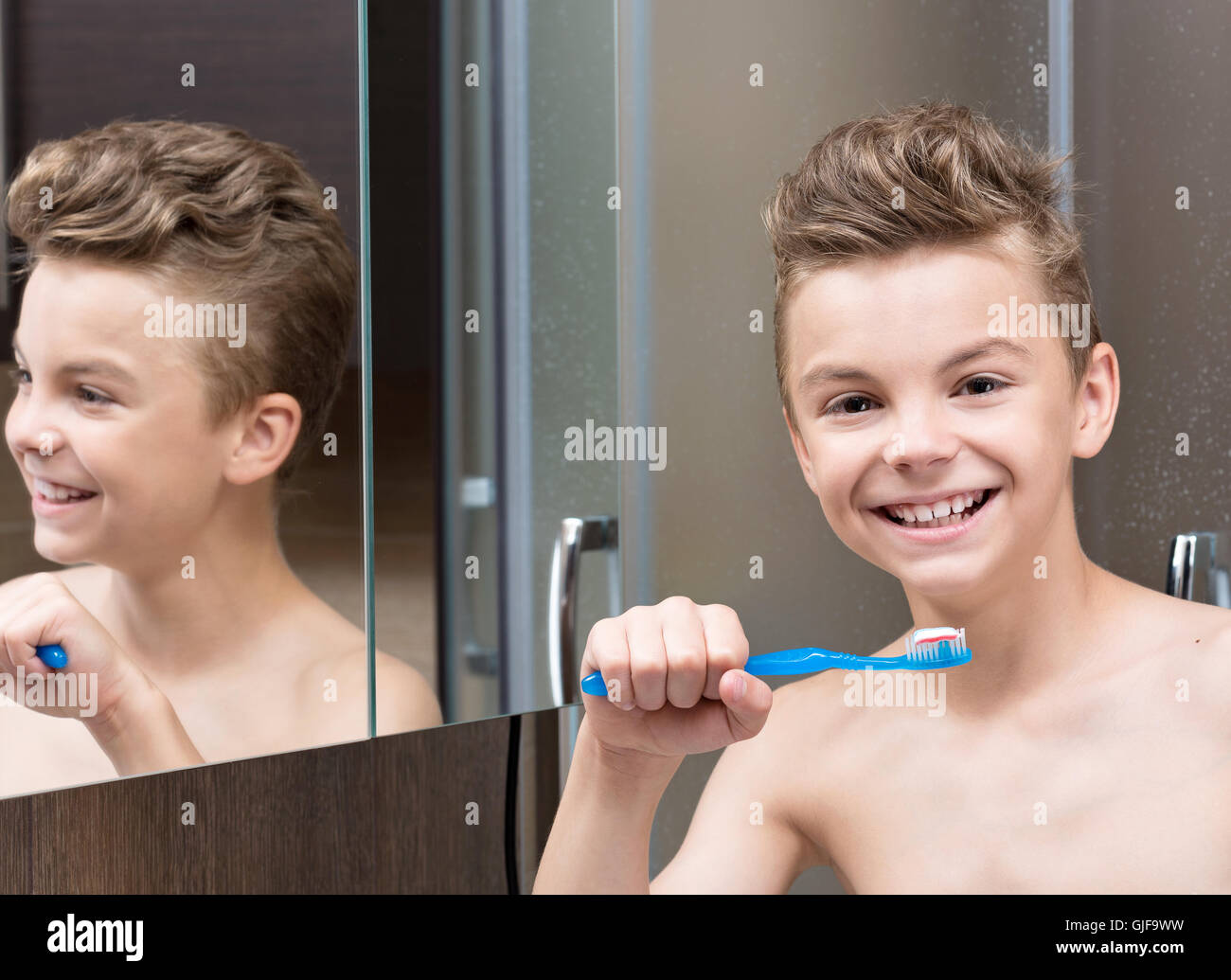 Teen boy brushing teeth Stock Photo