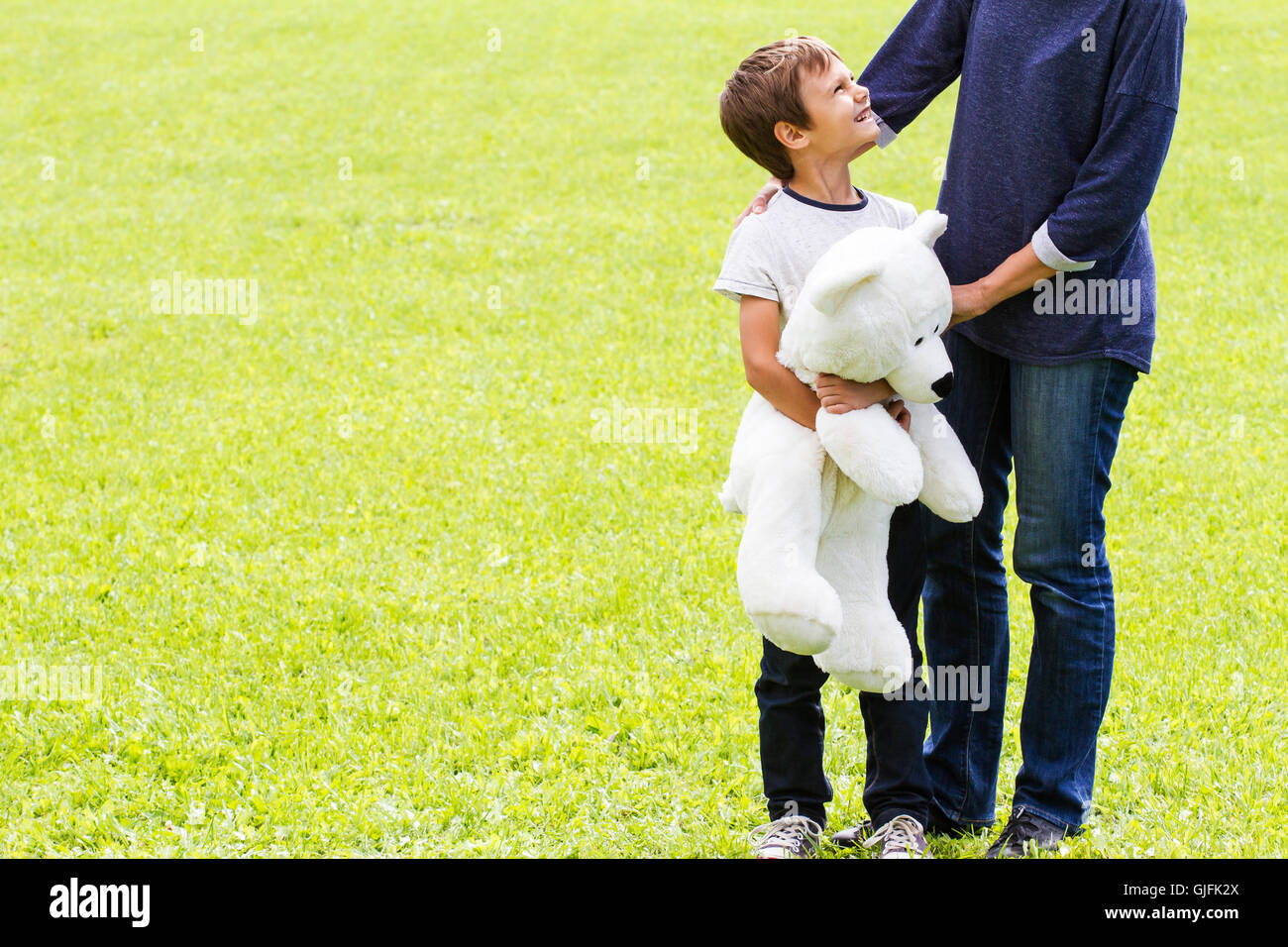 Mom hugging her son. Child have a teddy bear. Outdoor. Family concept Stock Photo