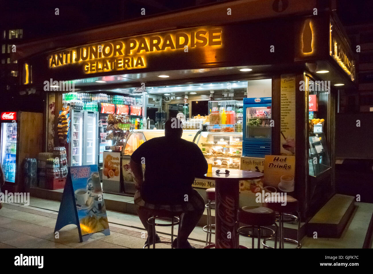 An obese man sat outside a seafront café at Sliema on the island of Malta Stock Photo