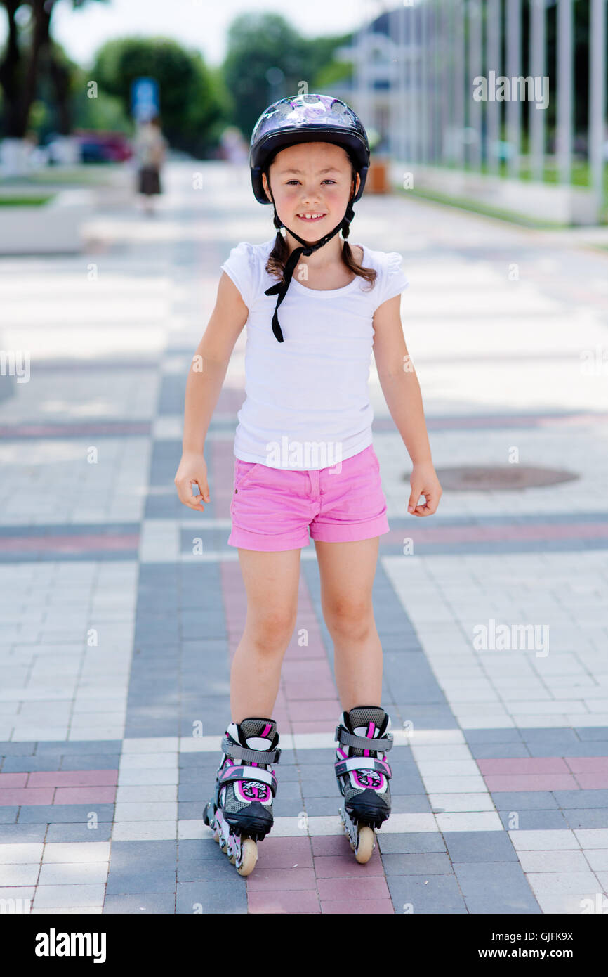 Little girl rides on roller skates at park Stock Photo Alamy