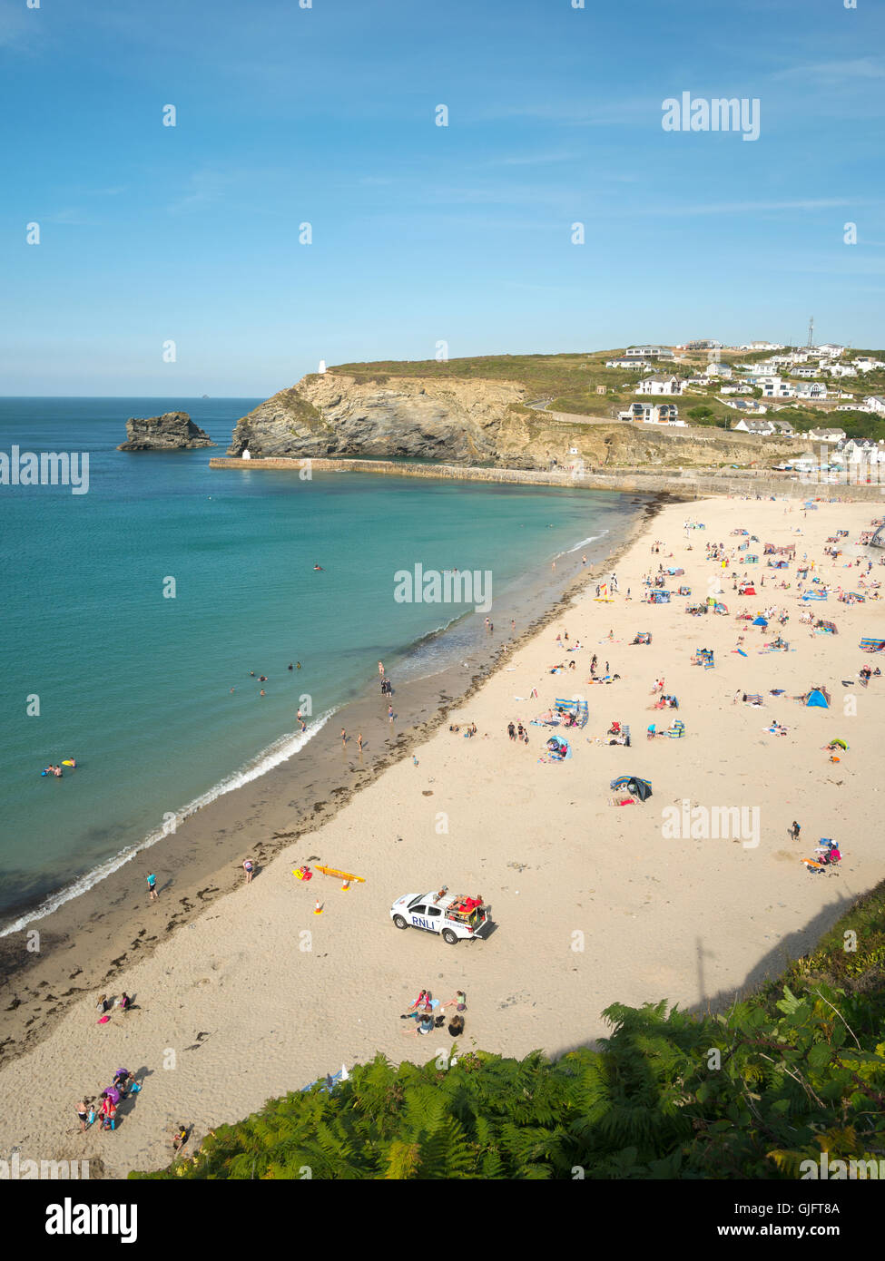 Portreath beach shore near high tide in Cornwall England. Looking down from a cliff top on a sunny summers day. Stock Photo