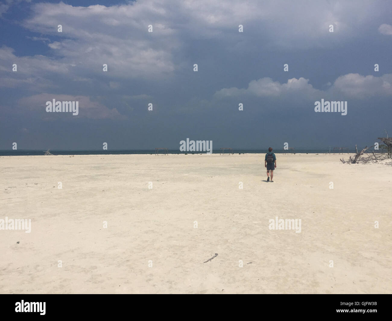 A young man walks across a wide, deserted beach that stretches across the eastern end of Cayo Levisa. 2016. Stock Photo