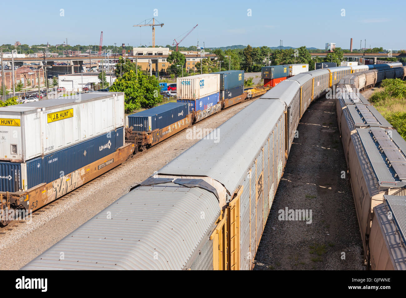 Double-stack intermodal railcars with containers and autoracks with cars sit on CSX sidings in downtown Nashville, Tennessee. Stock Photo