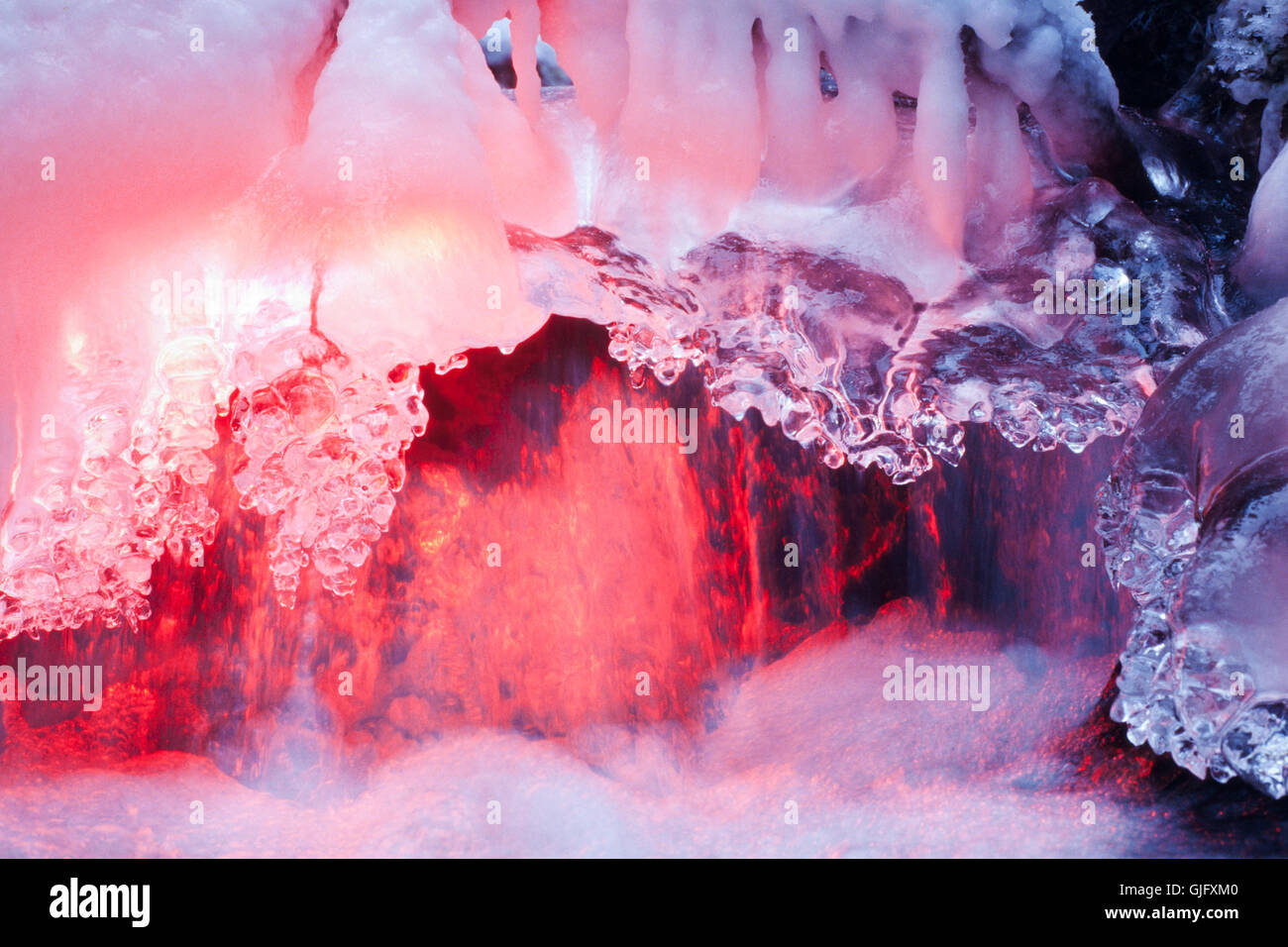 Freezing Waterfall glowing in red light Stock Photo