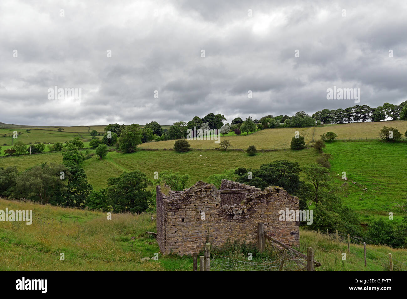 A crumbling dry stone building in the Peak District National Park sits amongst the rolling hills of the Pennines. Stock Photo