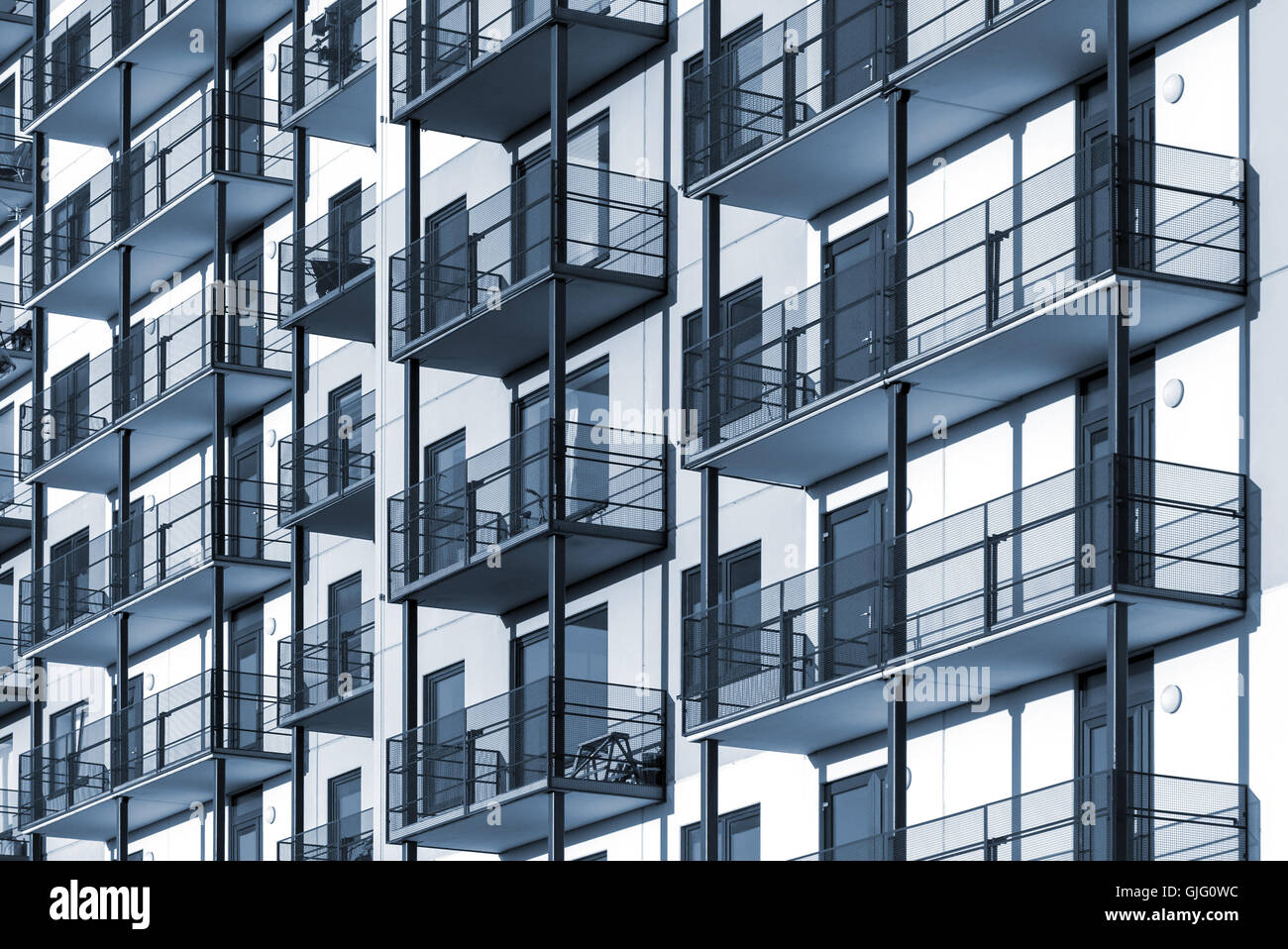 Blue colorized construction background picture of modern apartment building with balconies Stock Photo