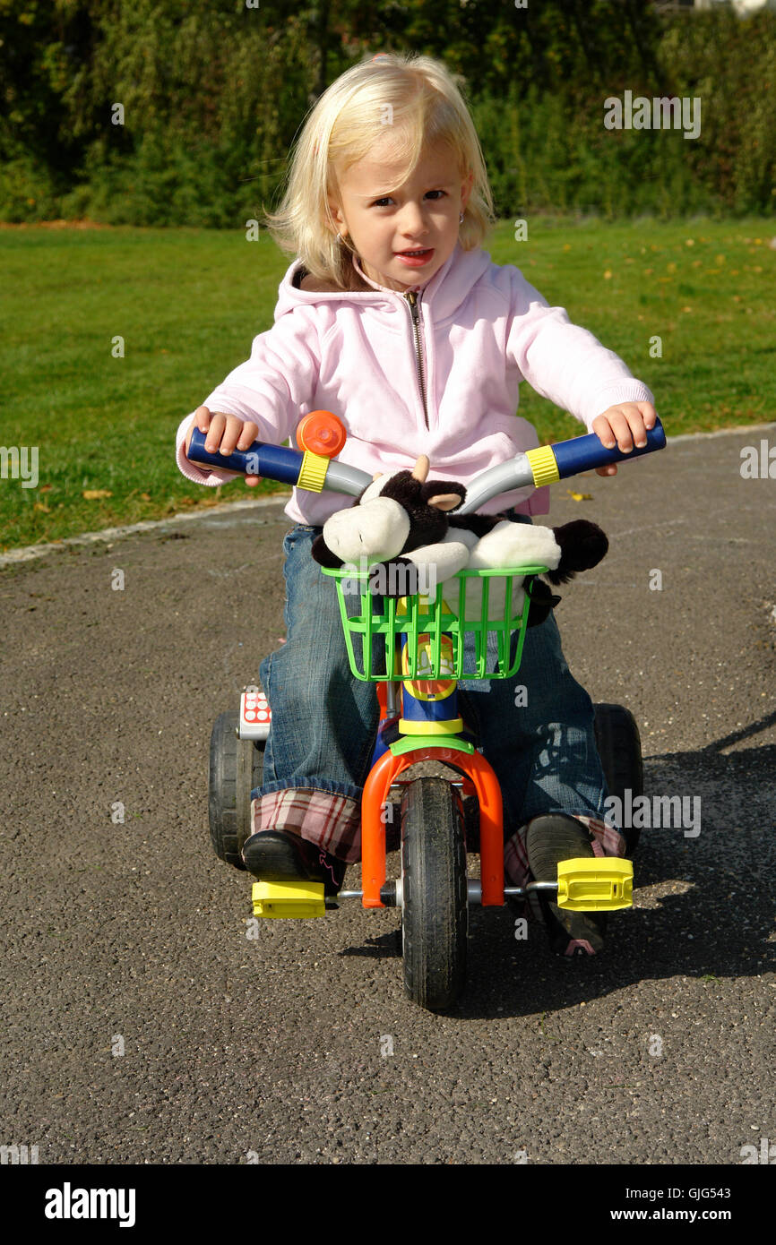 Toddler girl playing tricycle hi res stock photography and images