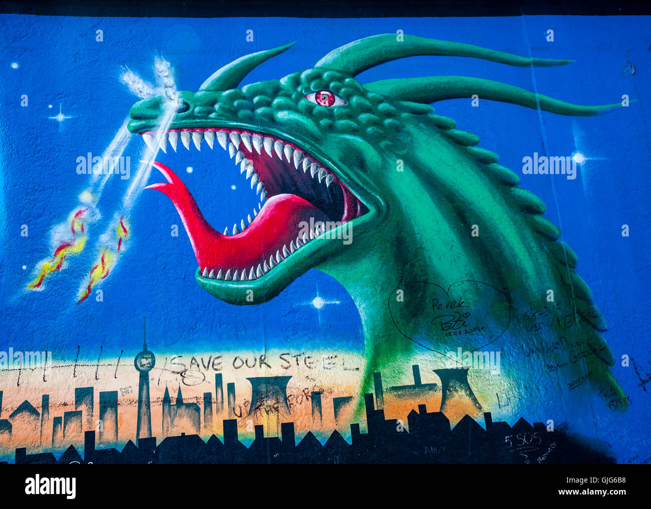 Detail of a fire breathing dragon graffiti mural on the Berlin wall, East Side Gallery, Friedrichshain, Berlin, Germany. Stock Photo
