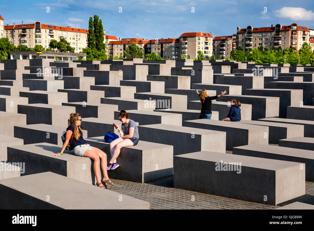 Tourists sitting on the concrete blocks of the Holocaust Memorial  to the murdered Jews of Europe, Berlin, Germany. Stock Photo