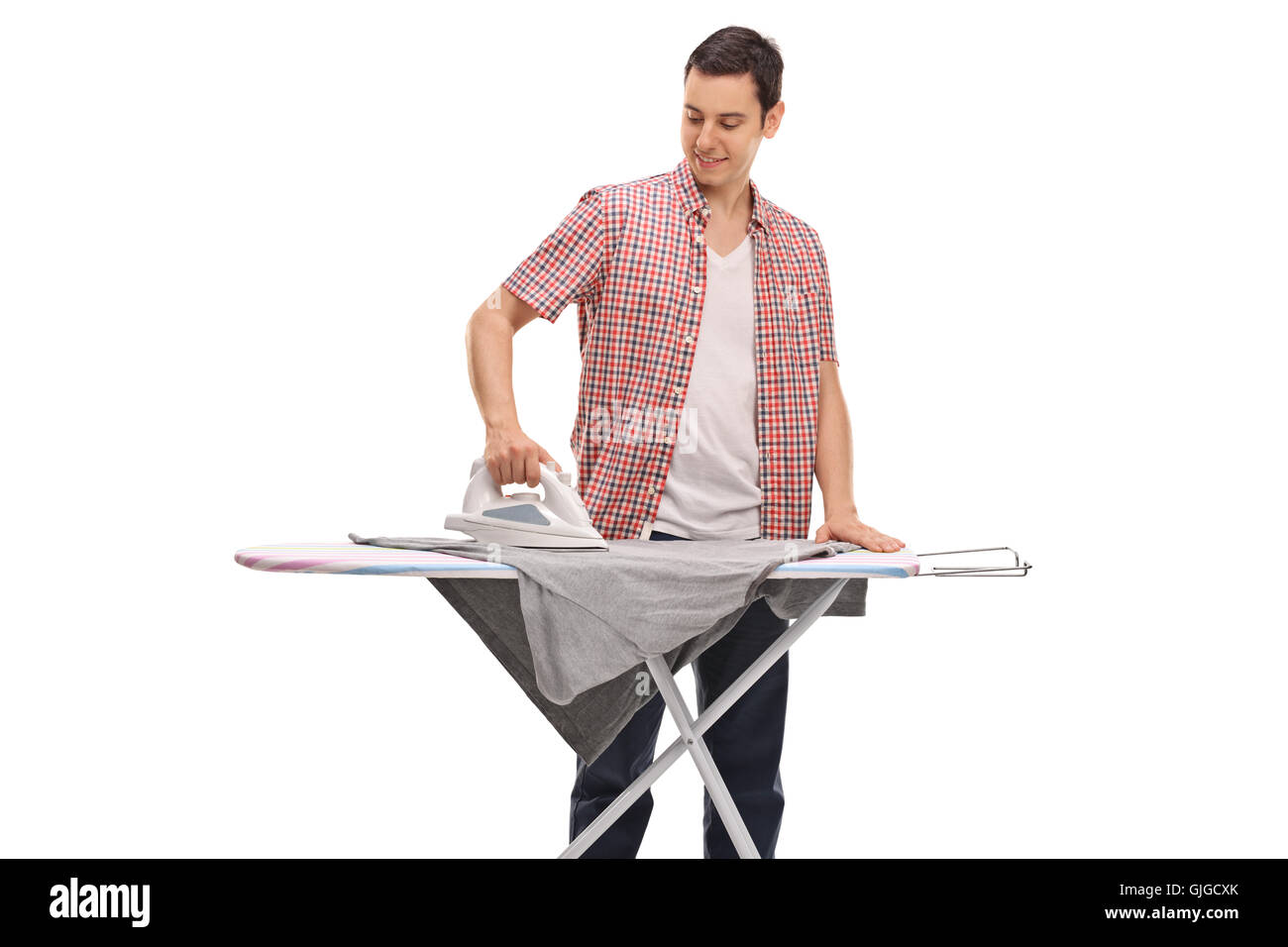 Guy ironing a tshirt on an ironing board isolated on white background