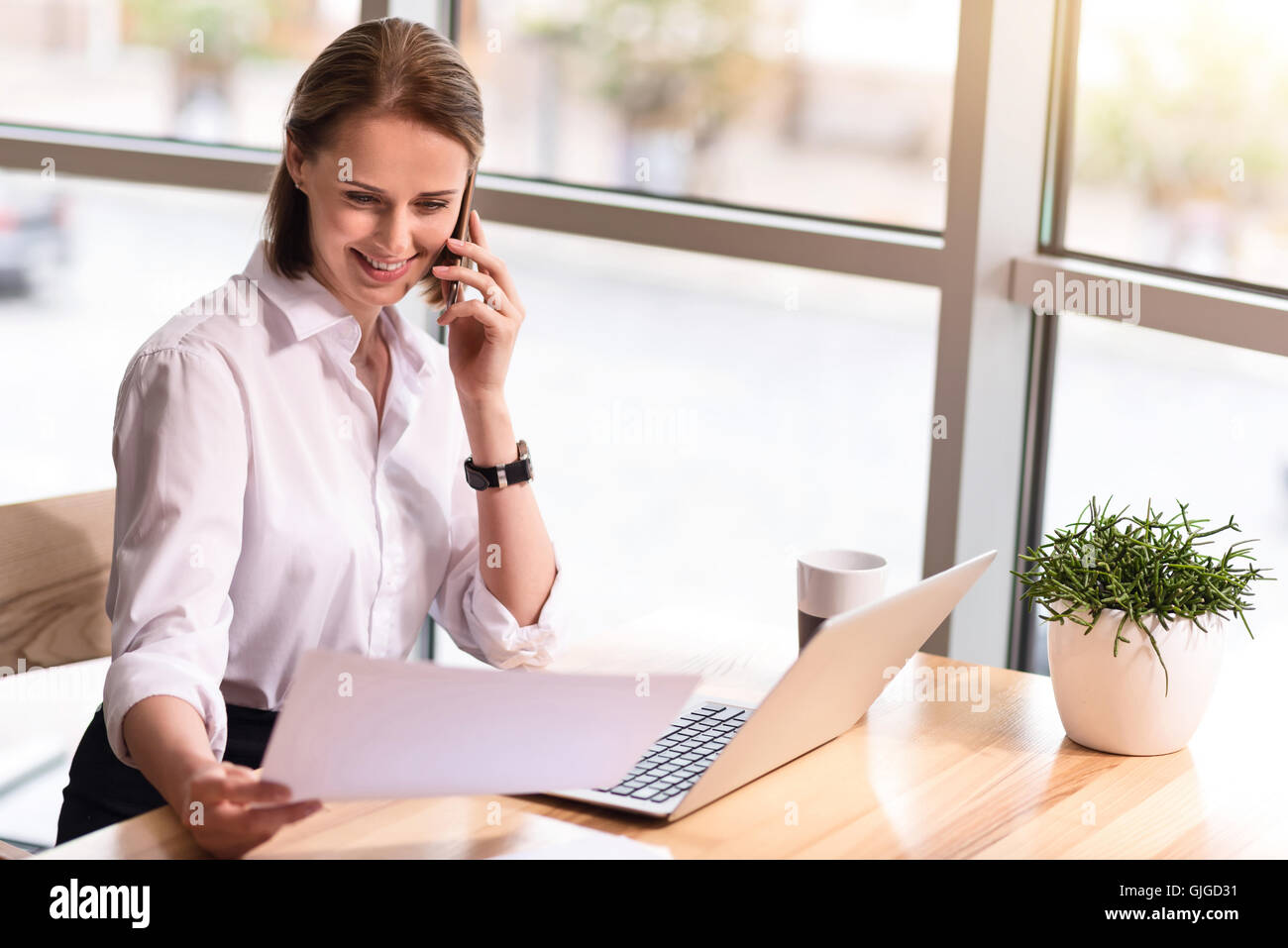 Pleasant delighted woman sitting at the table Stock Photo - Alamy