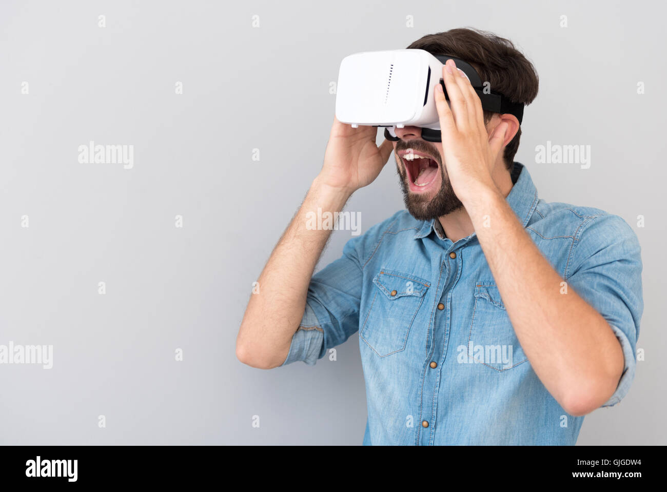 Emotional smiling man using virtual reality device Stock Photo - Alamy