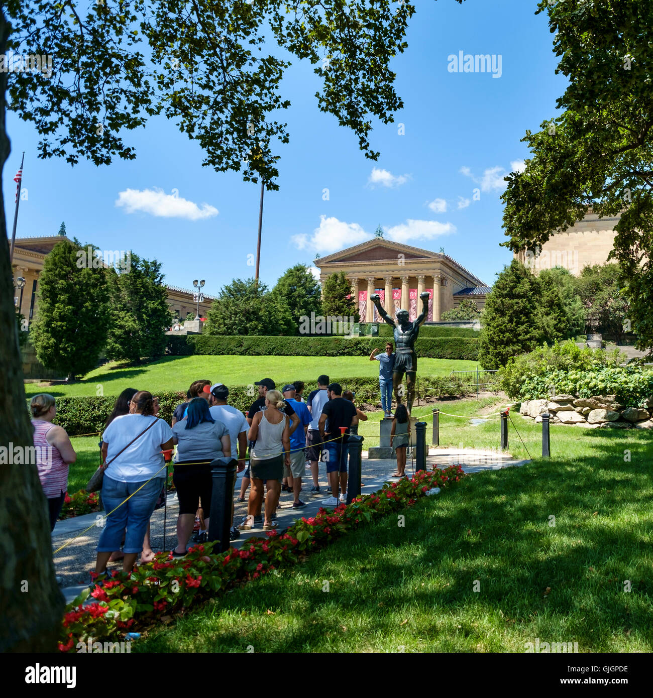People queue to have their photo taken with the bronze statue of Sylvester Stallone as Rocky Balboa outside the Philadelphia Museum of Art. Stock Photo