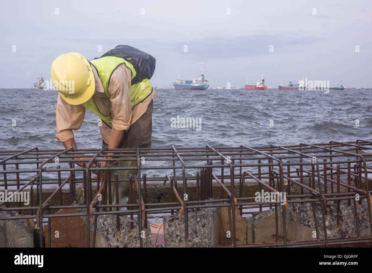 North Jakarta, Indonesia. 16th Aug, 2016. A worker contruct the new Jakarta's giant sea wall. Jakarta sinking by between 7.5 and 17 centimetres a year, more than 10 times faster than the sea is rising. Governments will split the 3.2 trillion rupiah ($263 million) cost for the first 8 kilometres of the wall. Developers would put up the remaining 24 kilometres by 2030 in exchange for the right to build on reclaimed land. © Anton Raharjo/Pacific Press/Alamy Live News Stock Photo