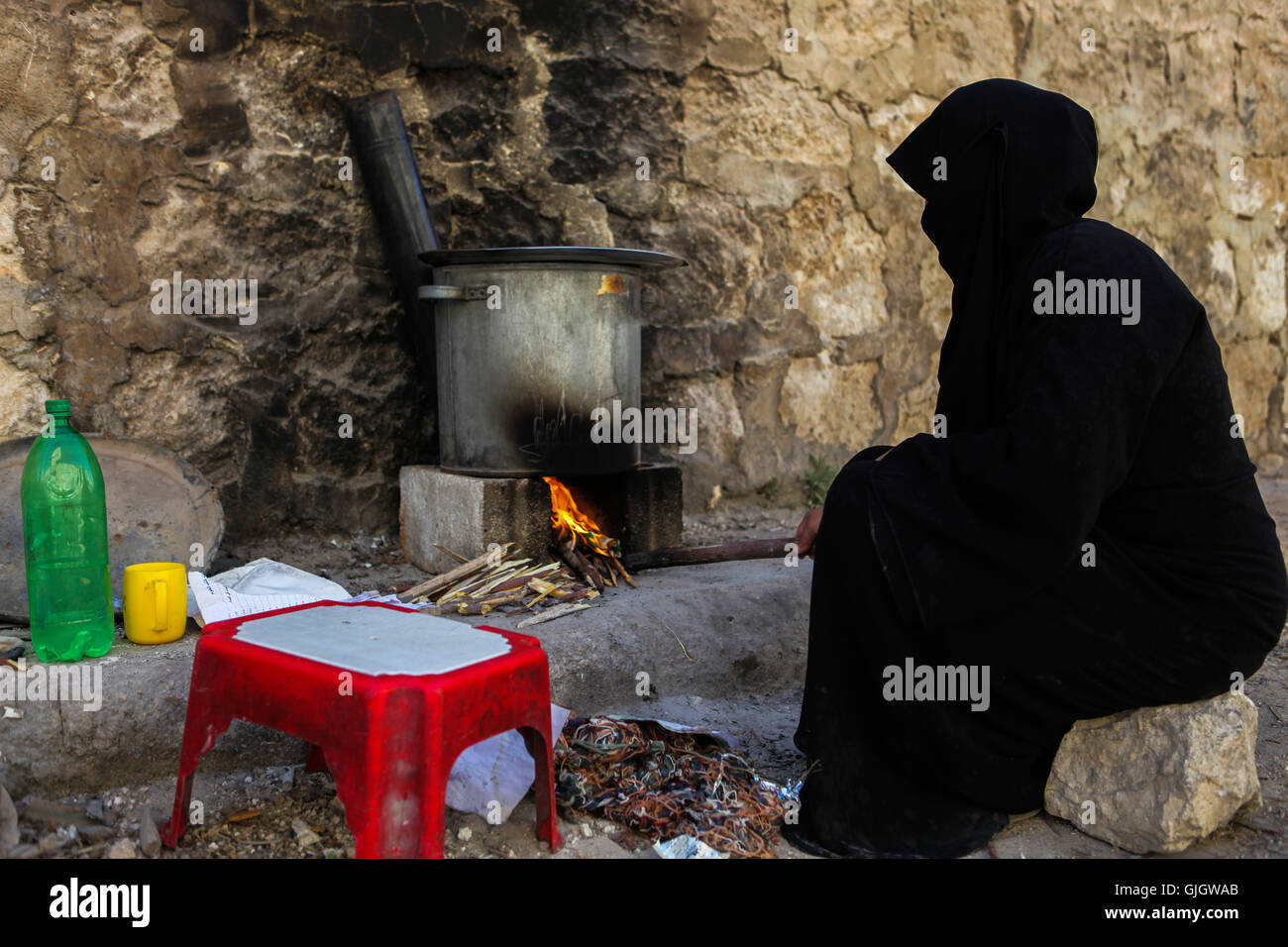 Aleppo, Syria. 20th May, 2016. A woman improvises some cooking outside due to very limited electricity and very limited and expensive gas in Aleppo © Louai Barakat/ImagesLive/ZUMA Wire/Alamy Live News Stock Photo