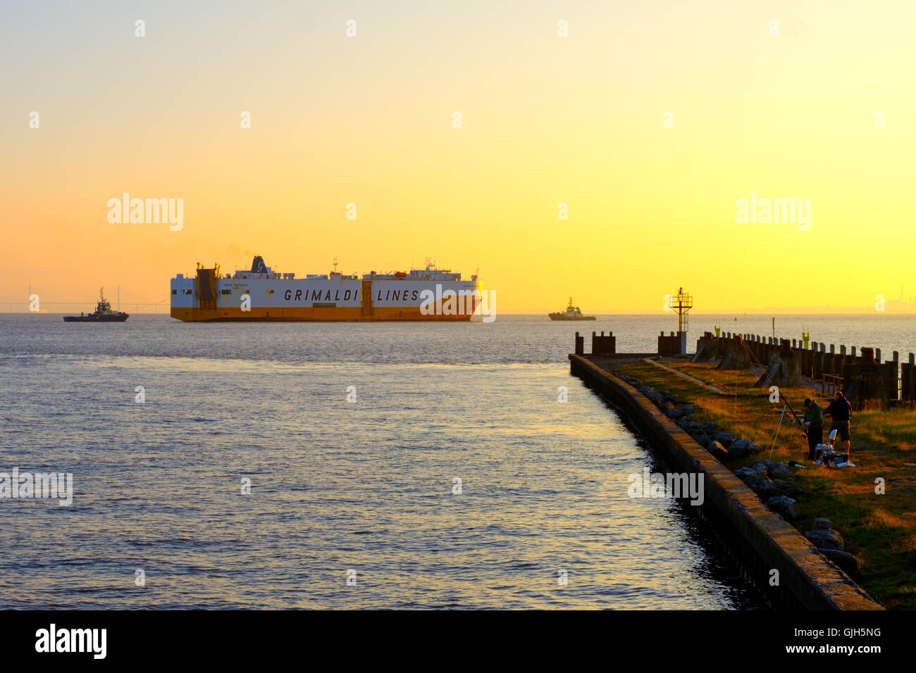 Severn Estuary, Avonmouth, UK. 17th August 2016: A car transporter is guided into Royal Portbury Dock but two tugs as high tide in the Bristol Channel coincides with a glorious sunrise. Credit:  Stephen Hyde/Alamy Live News Stock Photo