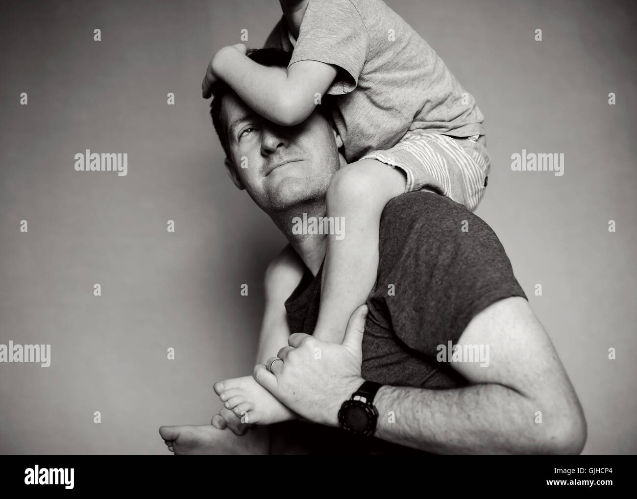 Boy sitting on his father's shoulders Stock Photo